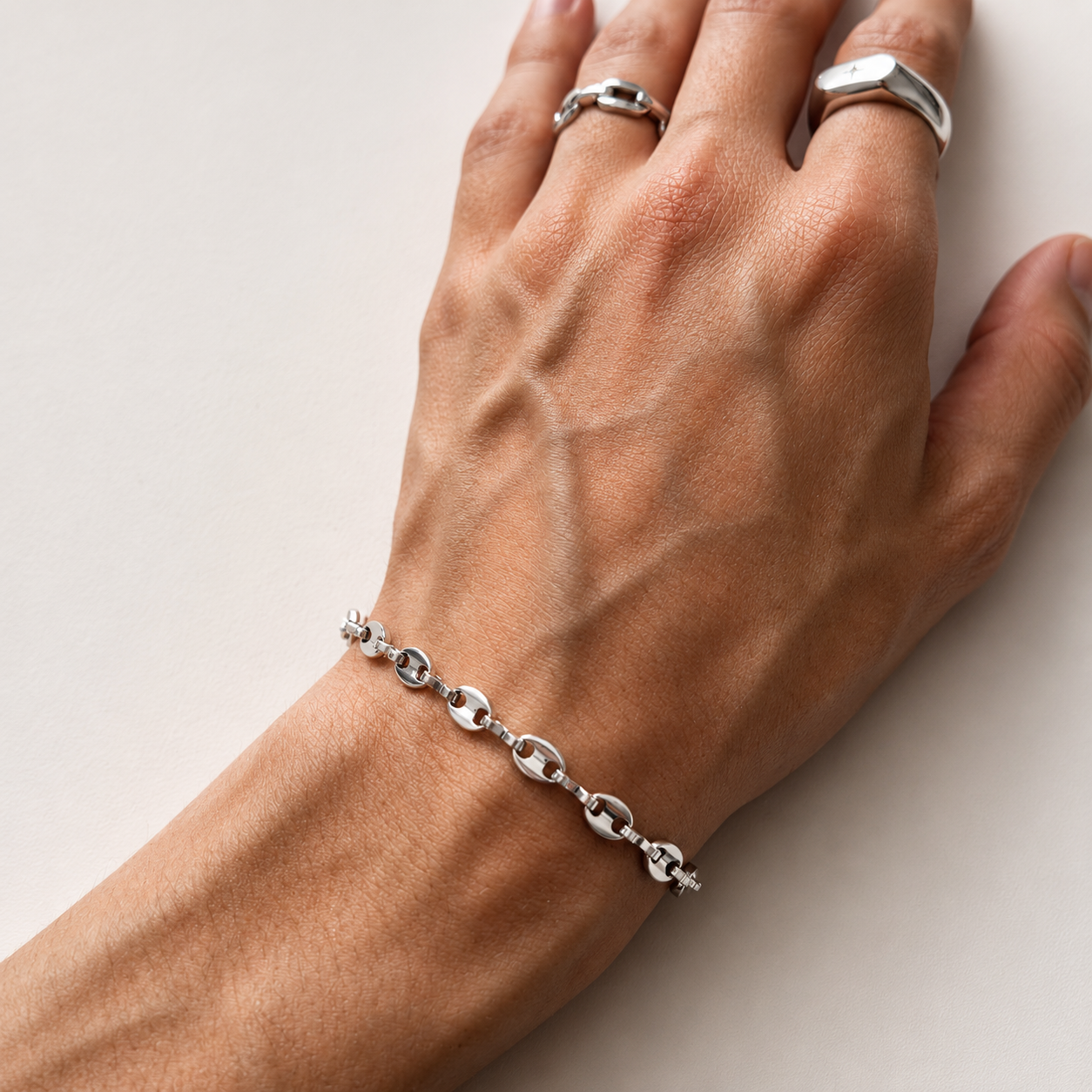Coffee Bean Bracelet - Silver (5mm) showcased on a hand with silver rings, highlighting its stylish design.