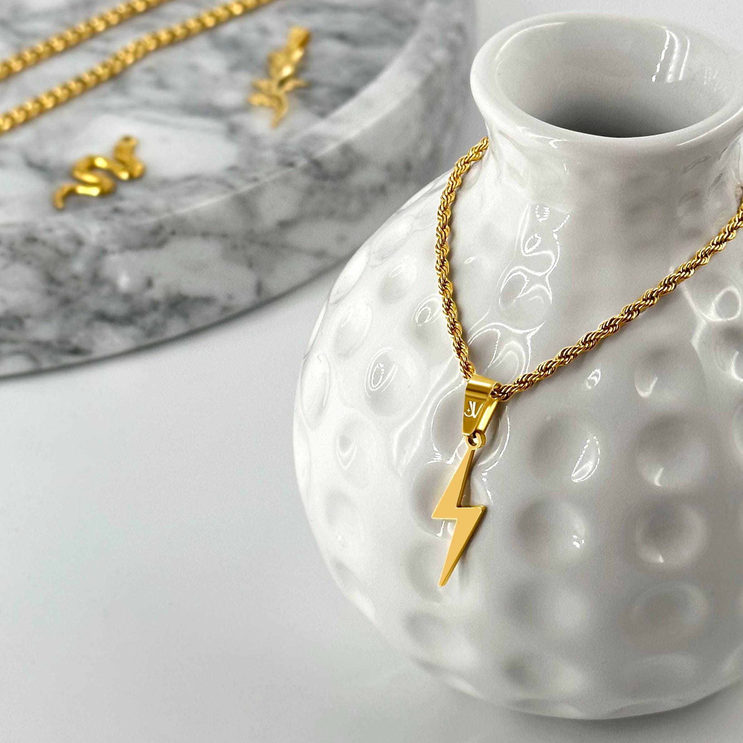Gold flash lightning bolt pendant on 2mm rope chain, styled product scene, JVillion