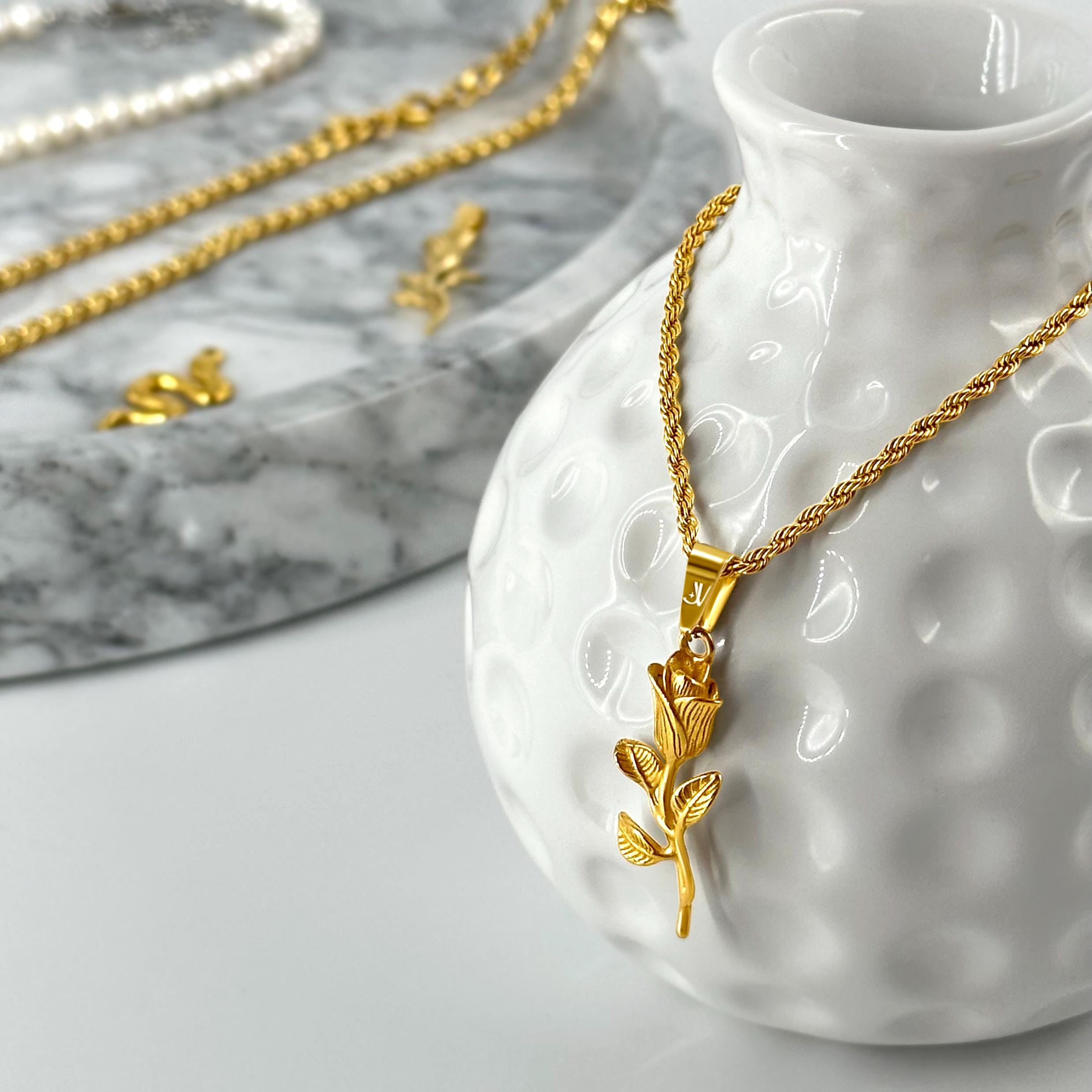 Gold rose flower pendant on 2mm rope chain, styled product scene, JVillion