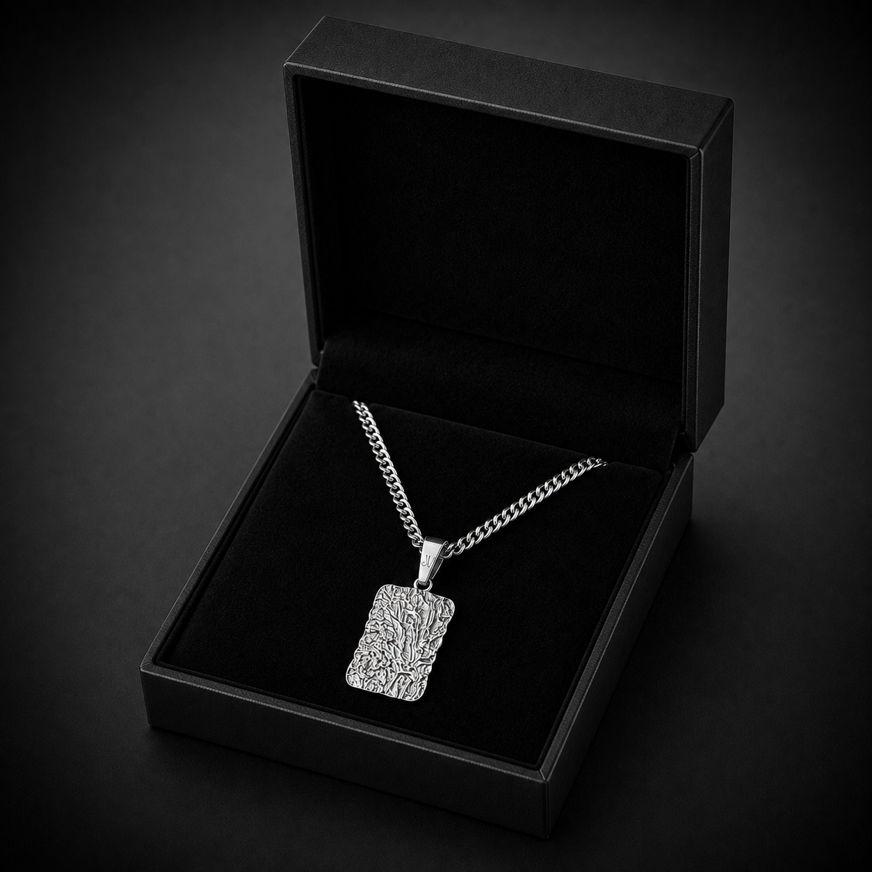 Zilverkleurige getextureerde lava-taghanger aan een cubaanse schakelketting in een open zwart JVillion cadeaudoosje