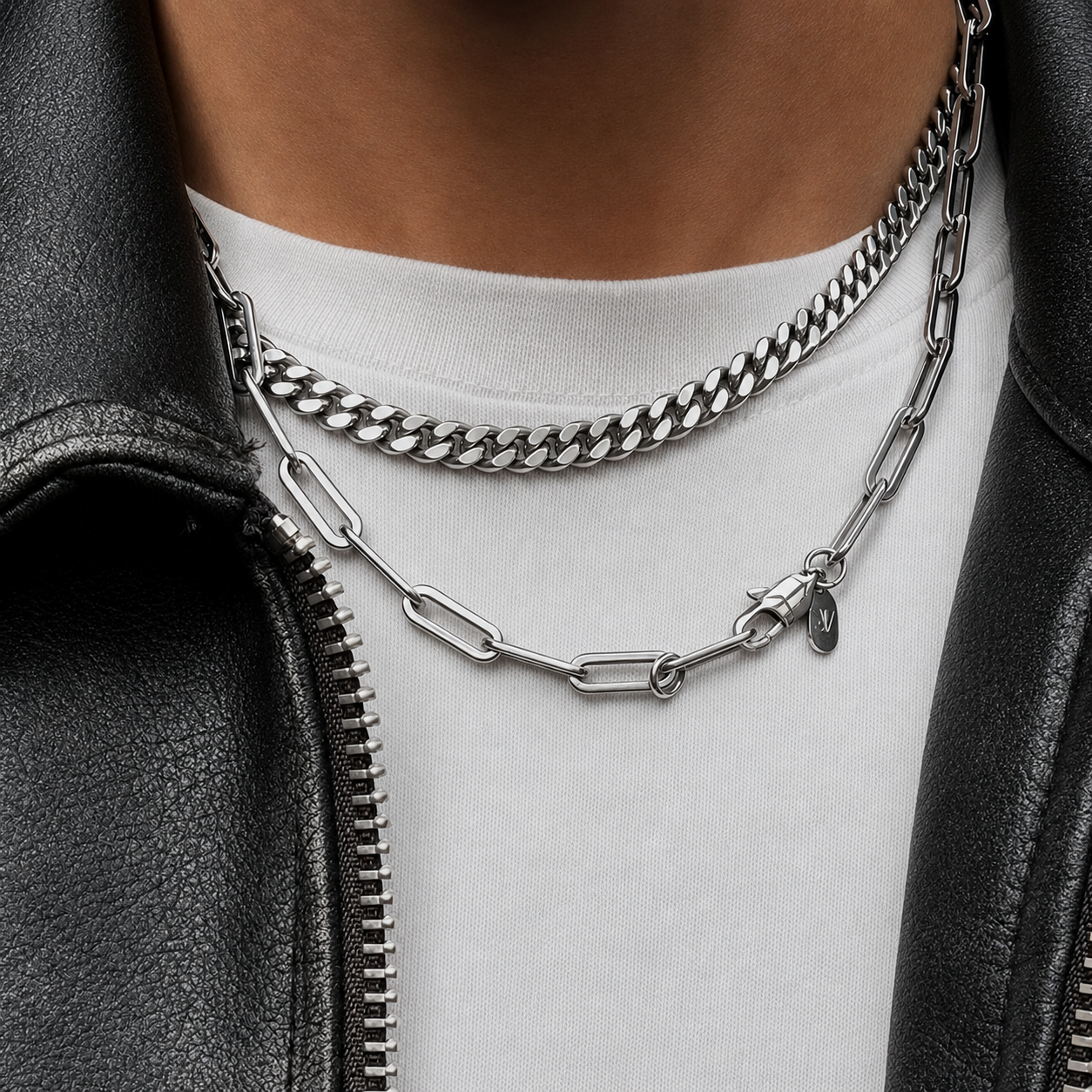 Silver paperclip link chain layered with a curb chain worn on a model in a leather jacket, JVillion