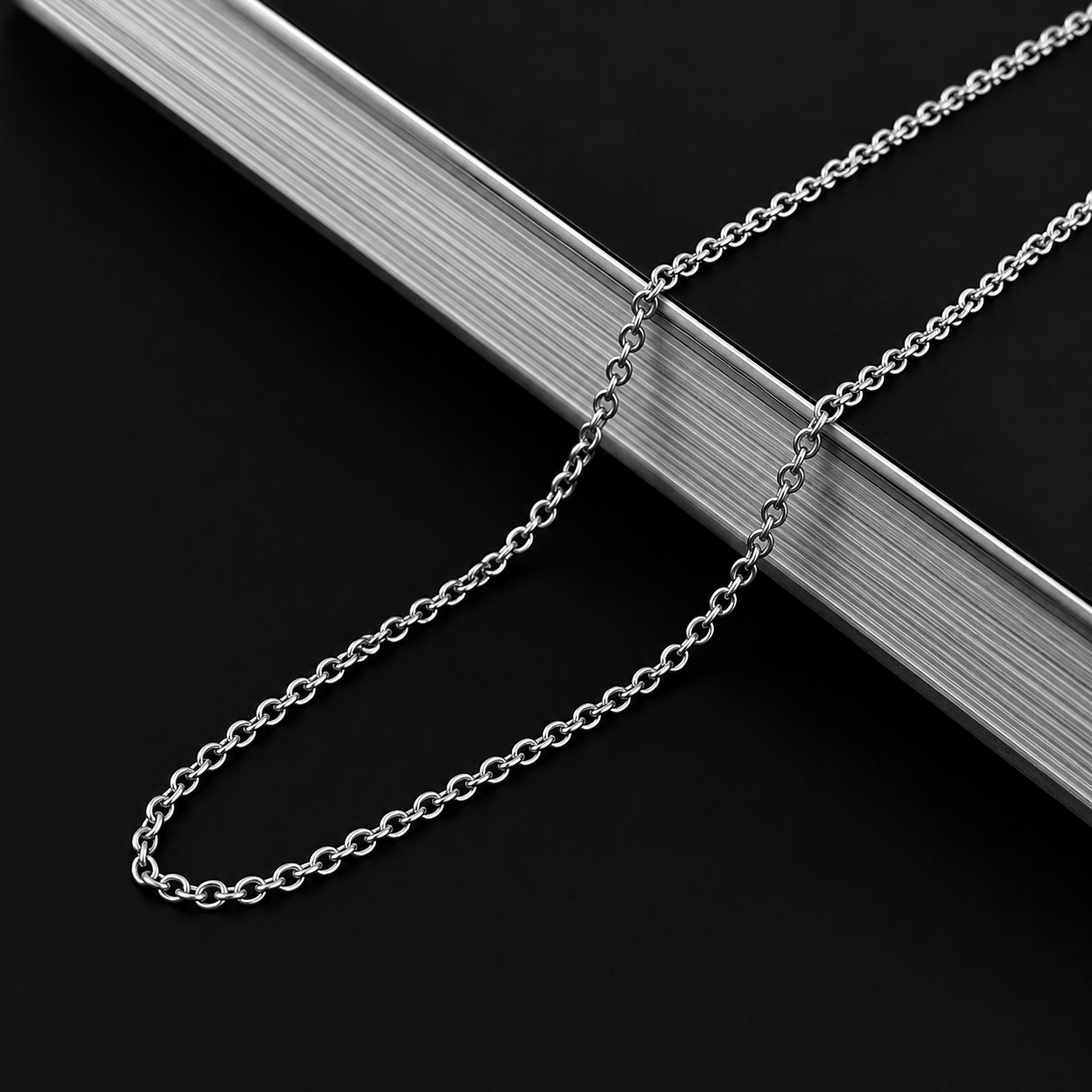 Collier maille forçat argenté 2mm drapé sur une barre en acier brossé, acier inoxydable, JVillion