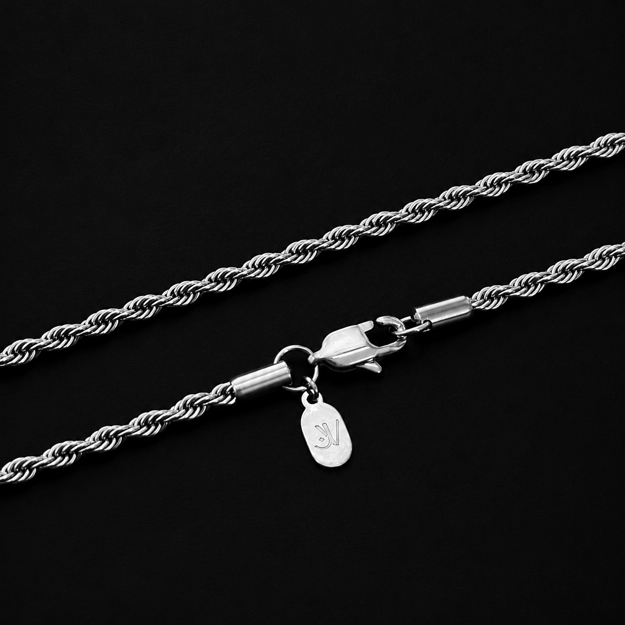 Nahaufnahme des Verschlusses der silbernen Kordelkette aus Edelstahl mit graviertem JVillion-Plättchen