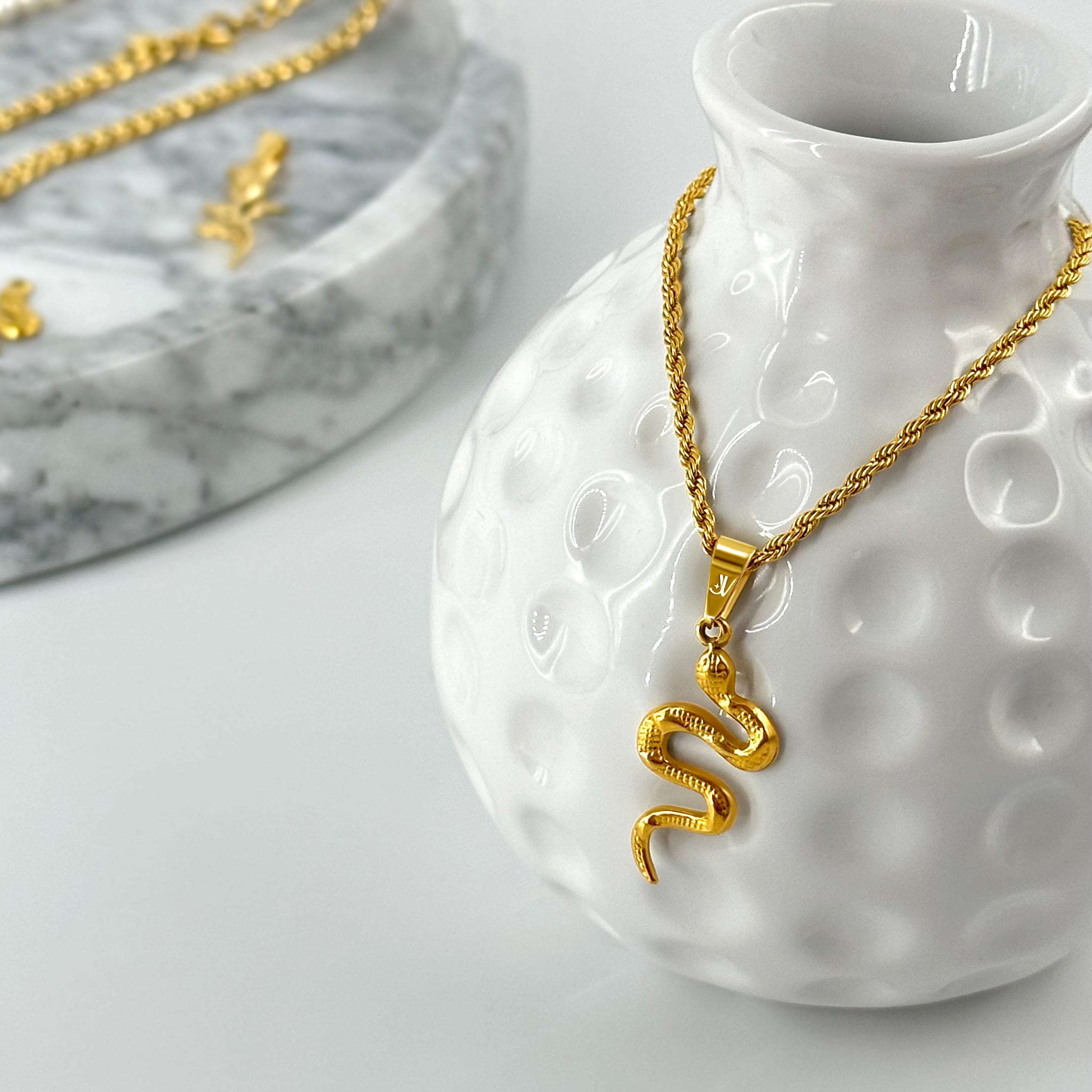 Gold viper snake pendant on 2mm rope chain, styled product scene, JVillion